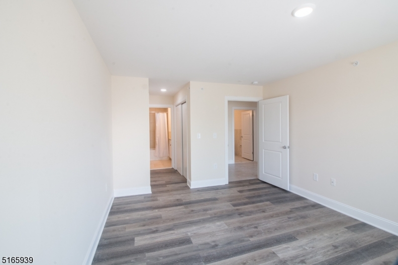 1664 Stuyvesant Avenue, Unit 306 Union, NJ 07083 - Photo 12 of 22 a view of an empty room with wooden floor and a window