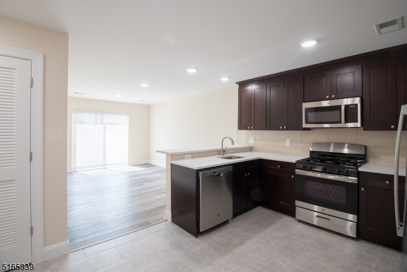 1664 Stuyvesant Avenue, Unit 306 Union, NJ 07083 - Photo 6 of 22 a kitchen with stainless steel appliances granite countertop a stove a sink and a microwave