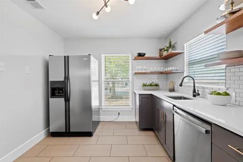 a kitchen with stainless steel appliances a refrigerator sink and cabinets