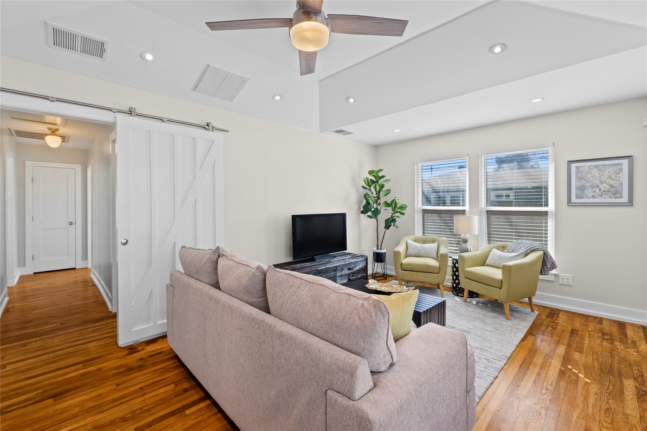 7803 Watson Street Austin, TX 78757 - Photo 6 of 30 Another view of the living room with updated windows and a door that can be closed to separate the hallway from the living area.