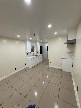 a view of a kitchen with white cabinets and wooden floor