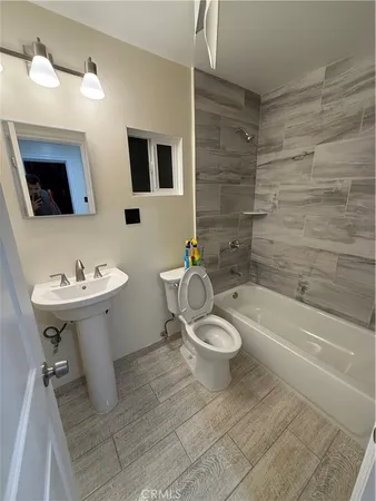 a bathroom with a sink toilet a mirror and shower