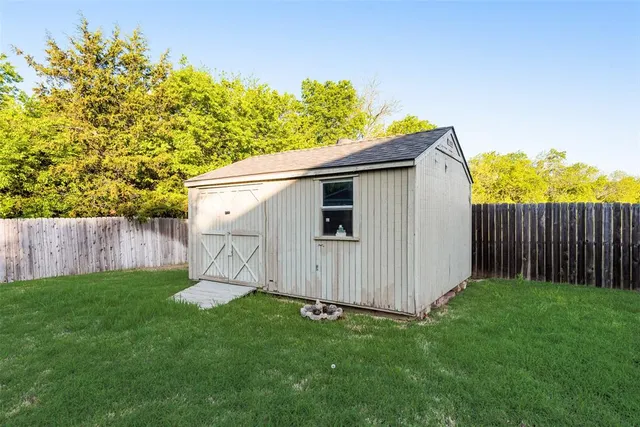 an empty room with wooden floor chandelier fan and windows