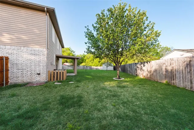 a view of backyard with small cabin and wooden fence