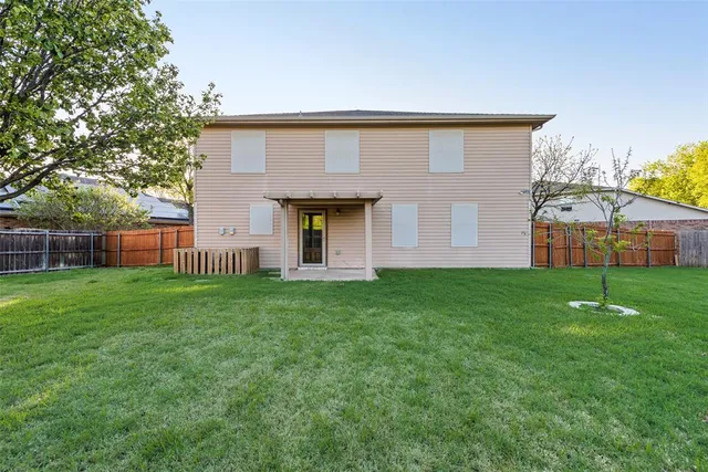 a view of a backyard with grass and a large tree