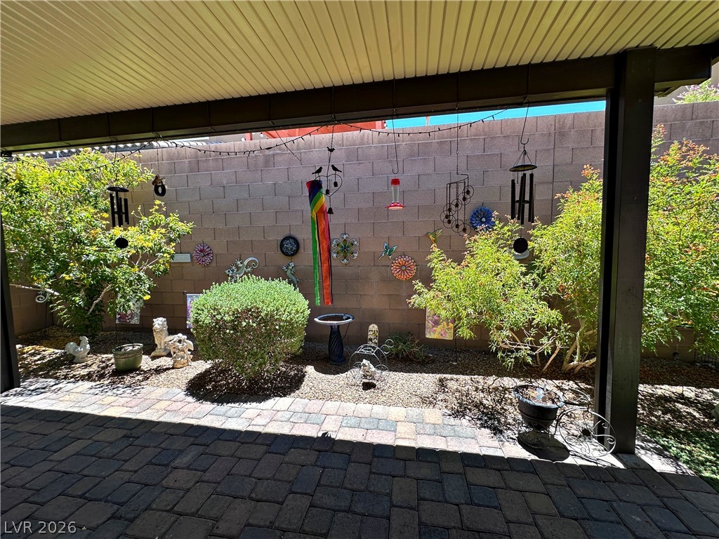 71 Newton Ridge Way Las Vegas, NV 89183 - Photo 35 of 40 A tranquil covered patio offers an inviting space for relaxation and garden enjoyment.