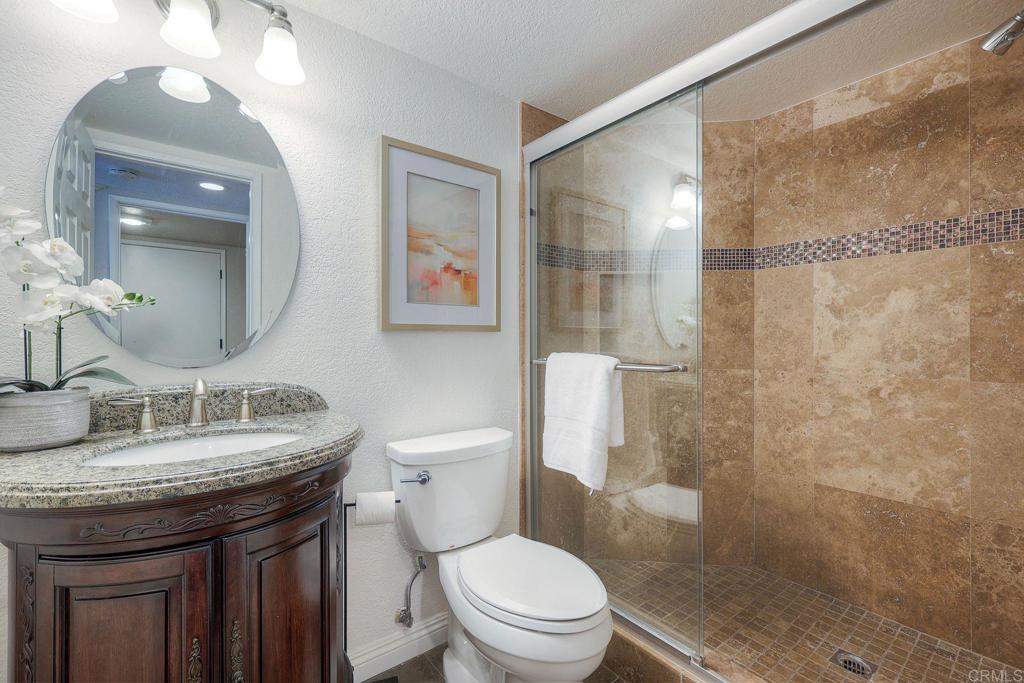 13979 Hickory Street Poway, CA 92064 - Photo 19 of 37 a bathroom with a granite countertop sink a toilet a mirror and shower