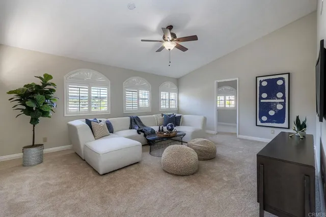 a living room with furniture a chandelier and a window