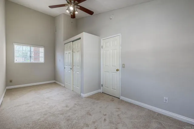 an empty room with fan and windows