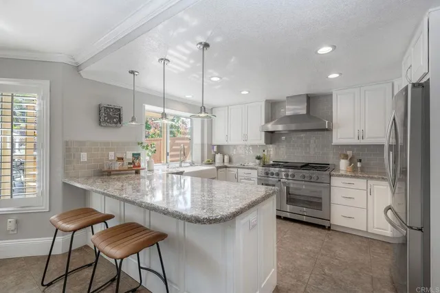 a kitchen with stainless steel appliances granite countertop a stove a sink a oven a dining table and chairs with wooden floor