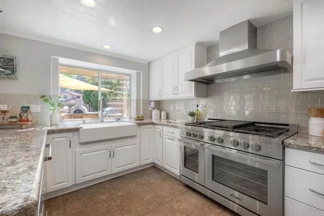 a kitchen with stainless steel appliances granite countertop a sink and a stove