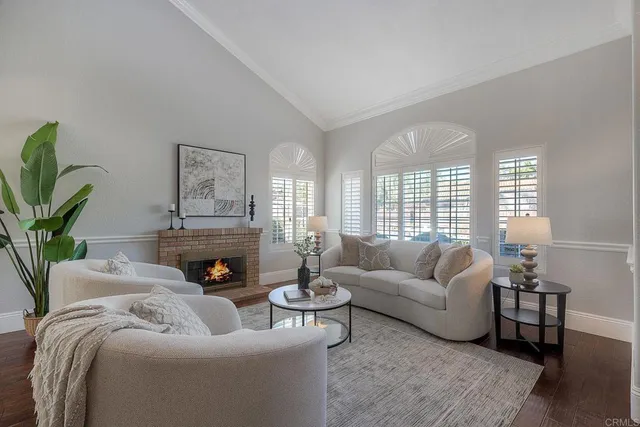 a living room with furniture fireplace and a large window