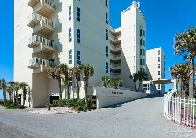 an front view of multi story residential apartment building with yard and sign board