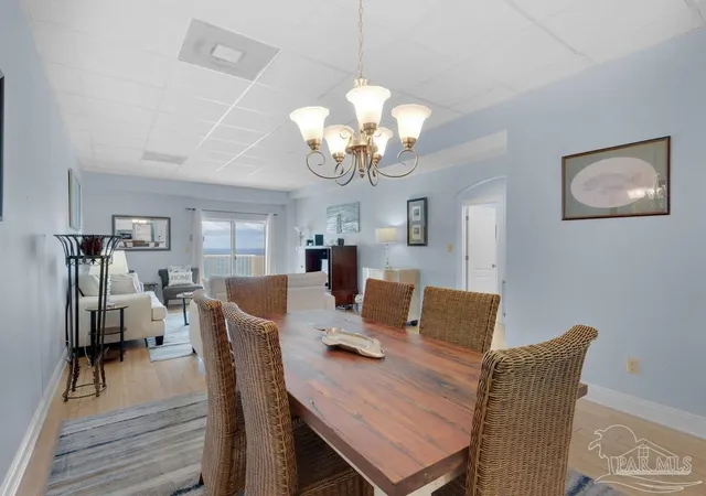 a view of a dining room with furniture a chandelier and wooden floor