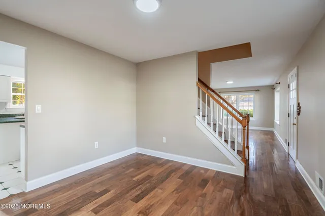 a view of a hallway with wooden floor and entryway