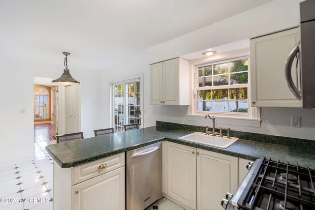 a kitchen with granite countertop a sink stove and cabinets