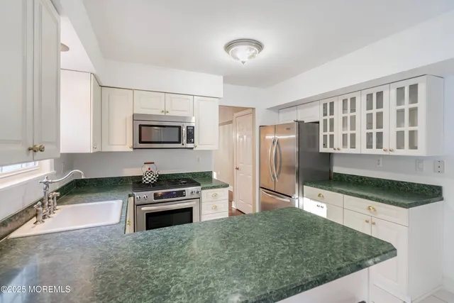 a kitchen with granite countertop a refrigerator and a sink