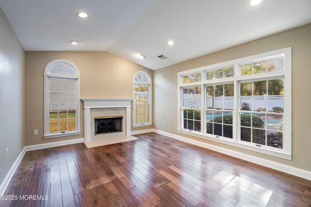 a view of an empty room with a window and fireplace