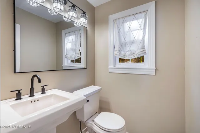 a bathroom with a toilet a sink and mirror