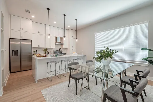 a kitchen with white cabinets and refrigerator