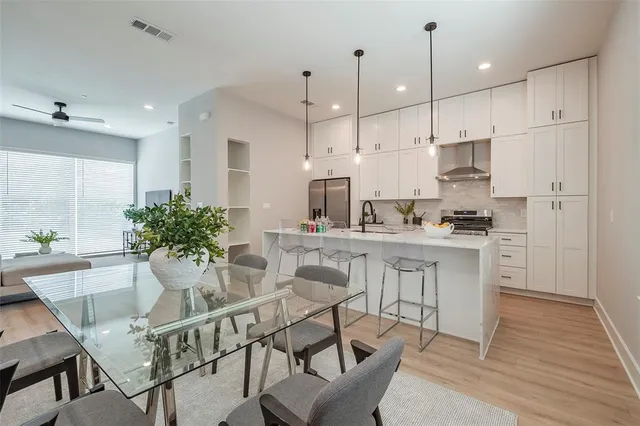 a kitchen with kitchen island white cabinets and stainless steel appliances