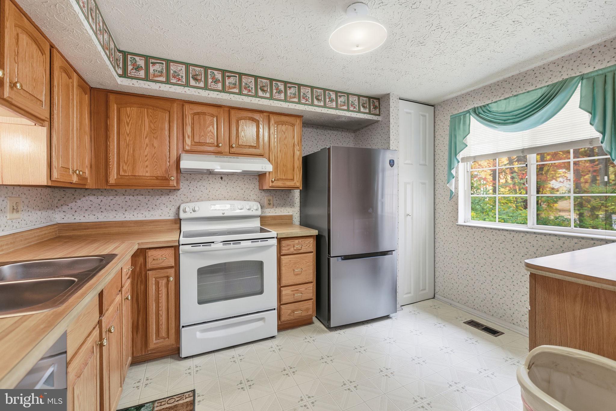 11563 Ivy Bush Court Reston, VA 20191 - Photo 7 of 48 a kitchen with stainless steel appliances granite countertop a refrigerator a stove and a sink with cabinets