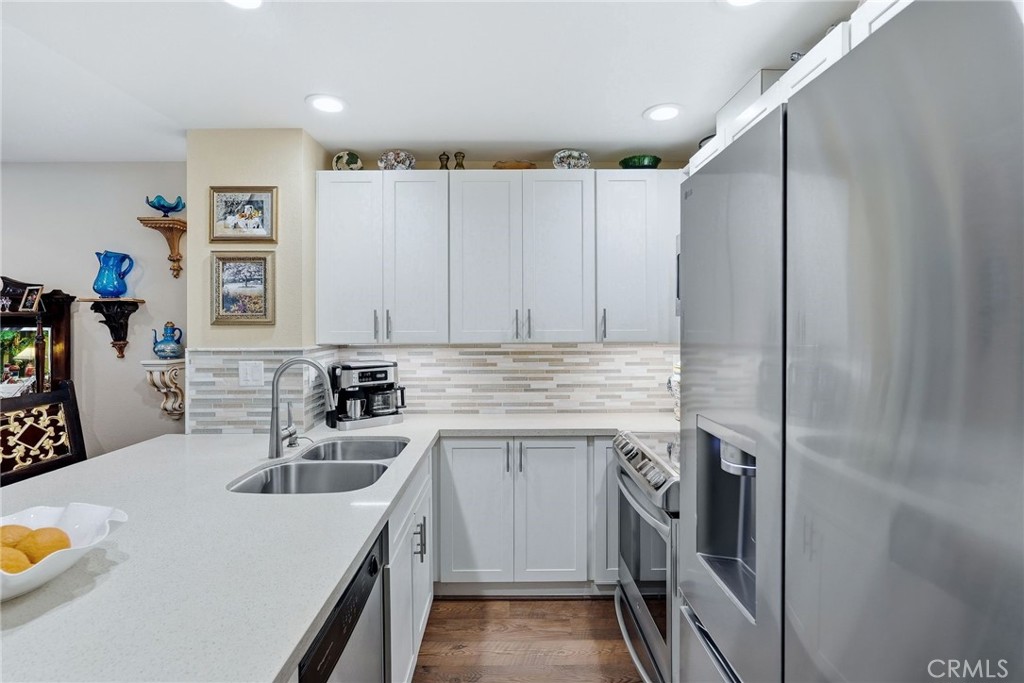 7890 East Spring Street, Unit 2L Long Beach, CA 90815 - Photo 16 of 47 a kitchen with stainless steel appliances granite countertop a sink and cabinets
