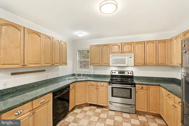 a kitchen with granite countertop a stove sink and cabinets
