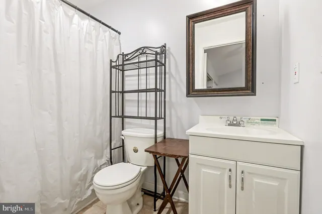 a bathroom with a toilet a sink and a mirror