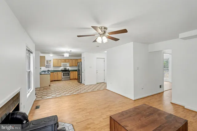 a living room with a couch and a dining table with wooden floor