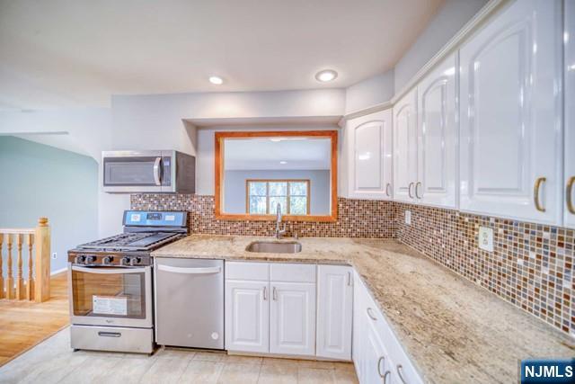 23 Smith Court Closter, NJ 07624 - Photo 13 of 23 a kitchen with granite countertop a sink a stove and cabinets