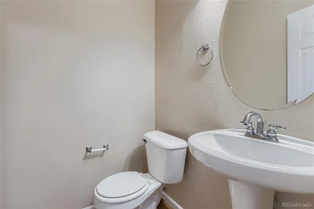 a white toilet sitting next to a bathroom sink