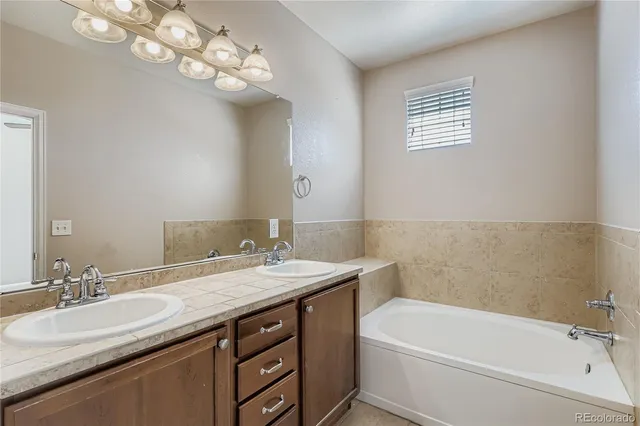a bathroom with a granite countertop sink a large mirror and a bathtub