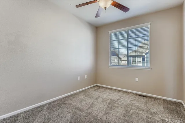 an empty room with a window and a fan