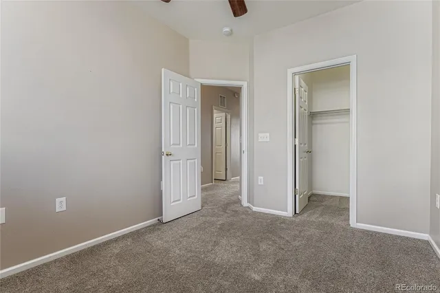 a view of an empty room with closet and wooden door