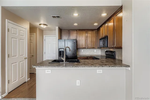 a kitchen with stainless steel appliances granite countertop a sink refrigerator and cabinets
