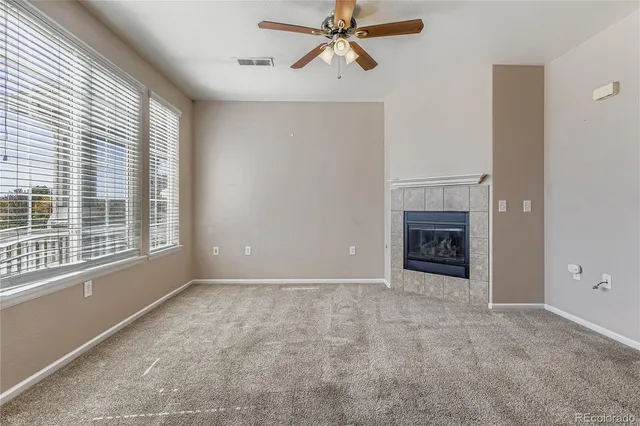 a view of empty room with a fireplace and windows