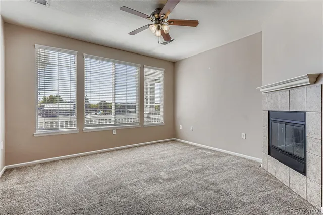 a view of an empty room with a window and a kitchen
