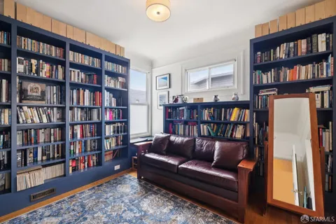 a living room with furniture and a book shelf
