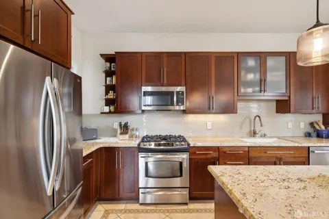 a kitchen with stainless steel appliances granite countertop a refrigerator and a stove