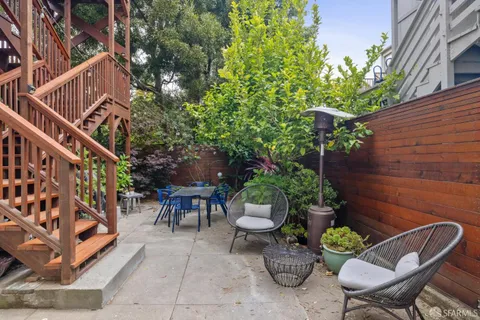 a view of a backyard with plants and a chairs