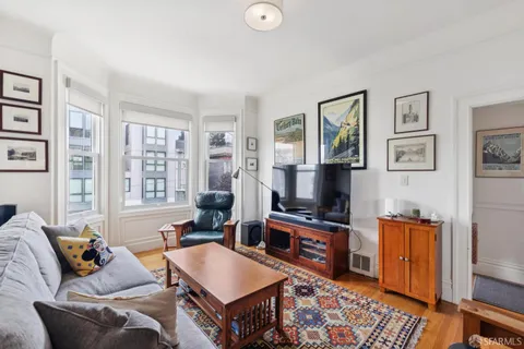 a living room with furniture a rug and a window