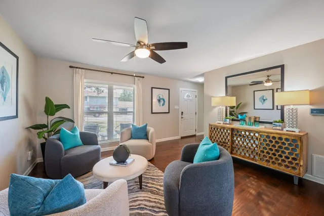 a living room with furniture and a wooden floor