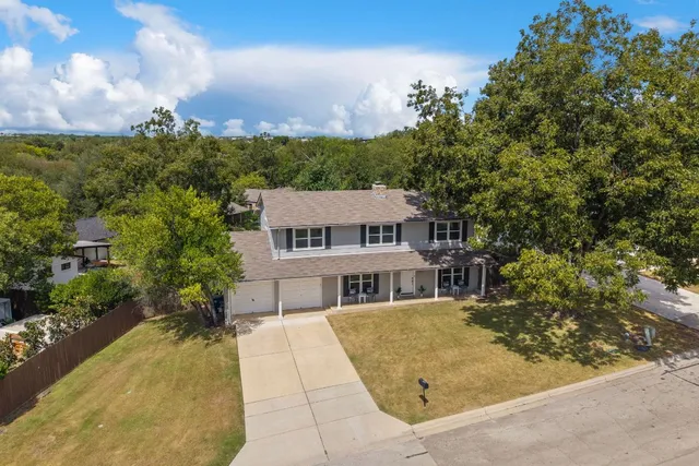 an aerial view of house with yard and mountain view in back