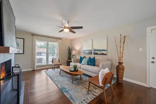 a living room with furniture a wooden floor and a large window