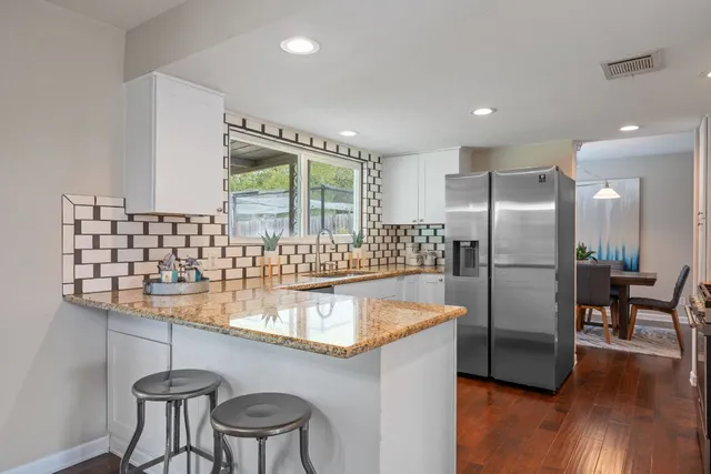 a kitchen with stainless steel appliances granite countertop a sink and cabinets