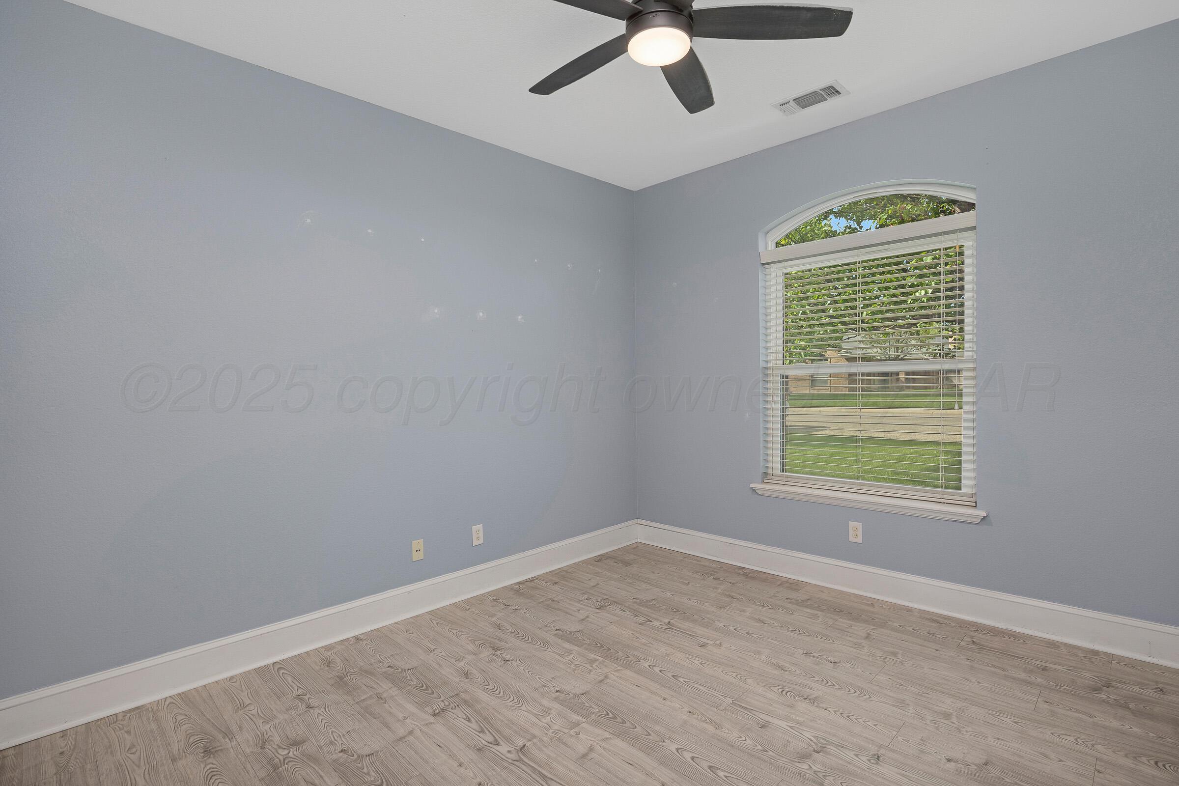 8211 Challenge Drive Amarillo, TX 79119 - Photo 21 of 31 an empty room with a window and a ceiling fan