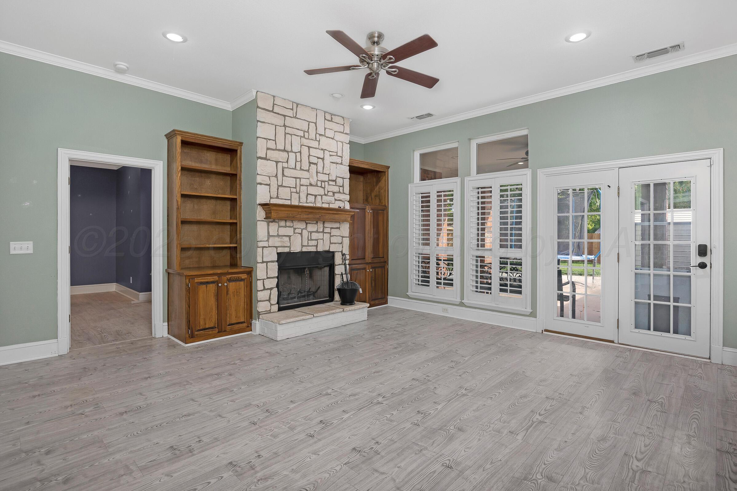 8211 Challenge Drive Amarillo, TX 79119 - Photo 3 of 31 a view of an empty room with a fireplace and a ceiling fan