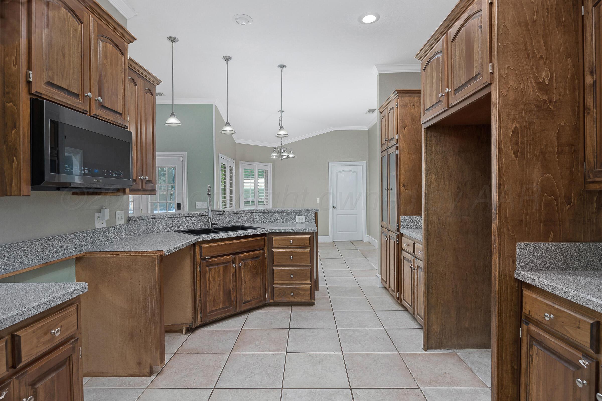 8211 Challenge Drive Amarillo, TX 79119 - Photo 7 of 31 a large kitchen with stainless steel appliances granite countertop a refrigerator and a sink