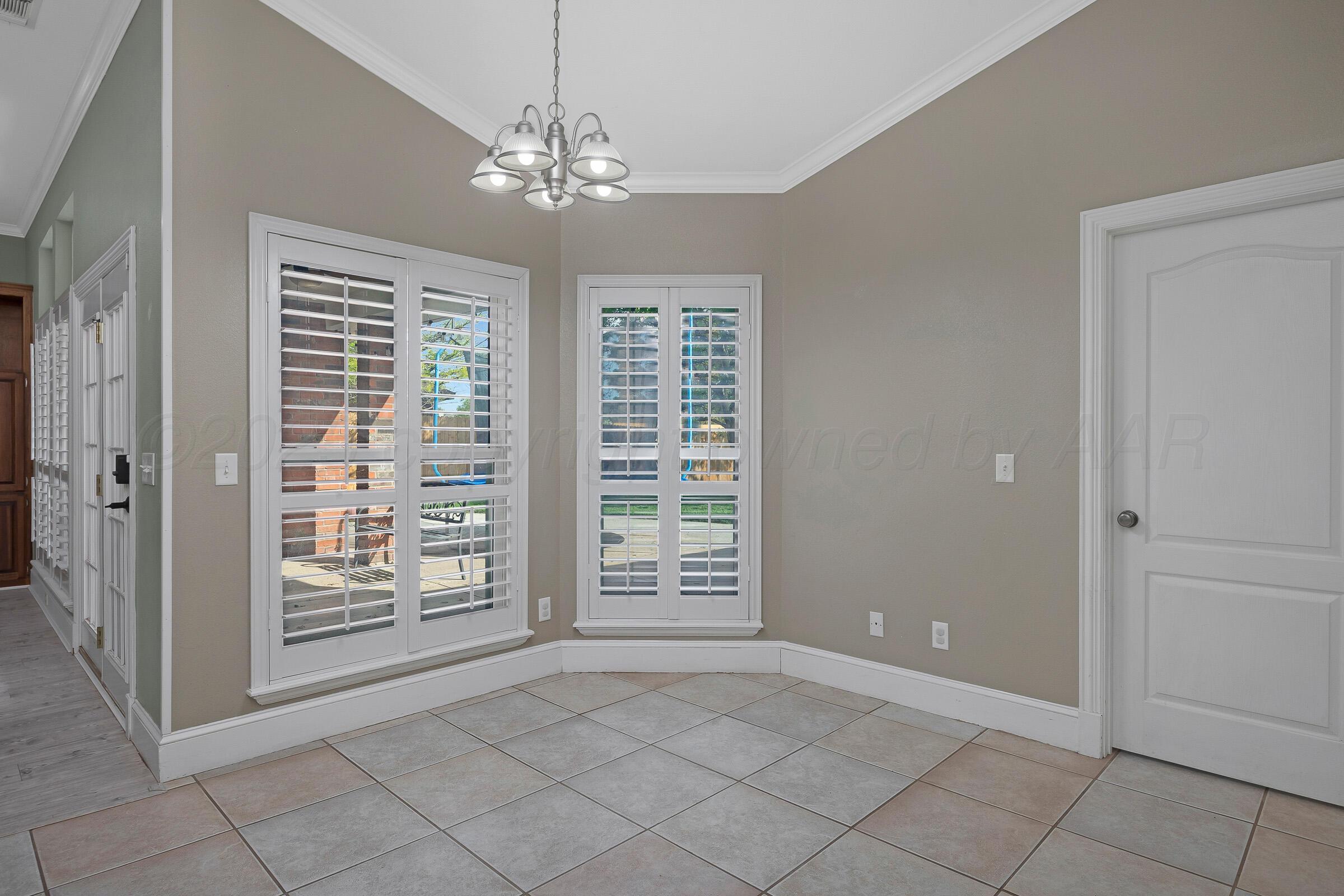 8211 Challenge Drive Amarillo, TX 79119 - Photo 9 of 31 a view of an empty room with windows and chandelier